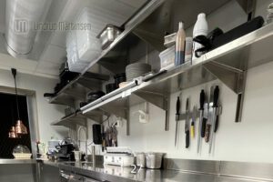 Veggmonterte hyller i rustfritt stål.